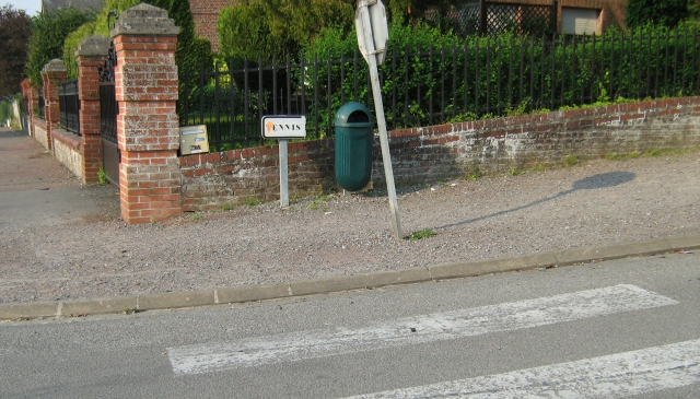 gravel footpath, faded pedestrian crossing markings and a signpost leaning a little in france